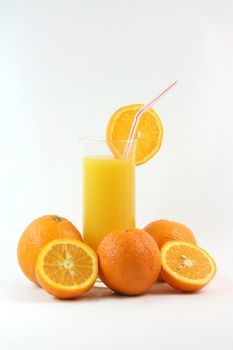 healthy eating glass of orange juice with straw and slice of orange and oranges