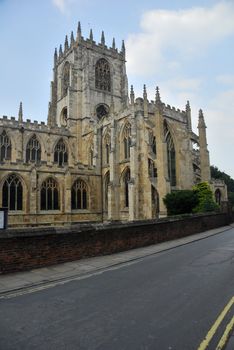 Gothic church under blue sky. Situated next to the road.