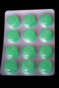 A strip of green sore throat lozenges