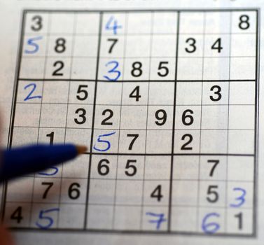 A left-handed person solving a Sudoku puzzle