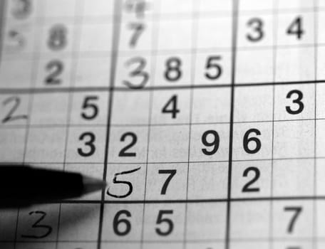 Left handed person solving a su doku puzzle