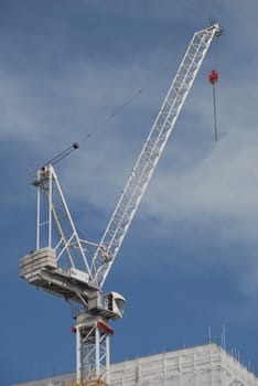 White crane stands out from the sky but corresponds very well with the building. 