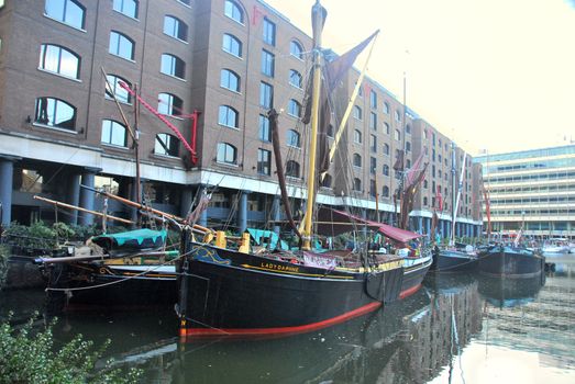 old boats in london marina create a nice contrast to new buildings around.