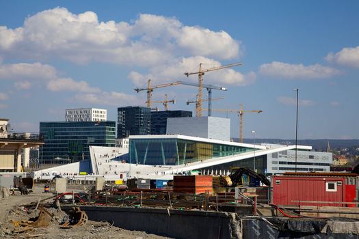 Construction in progress in Oslo, Noway. In the background we see the famous Opera house, as well as the new buildings called "barcode" being constructed. Illustrating a city on the rise, under construction.