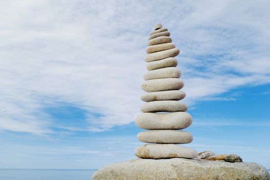 Pile of long pebbles in the balance on the seacoast