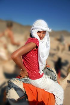 girl tourist in white kerchief riding camel in egypt