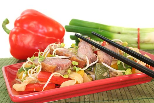 Duck breast with fried noodles, fresh vegetables and radish sprouts