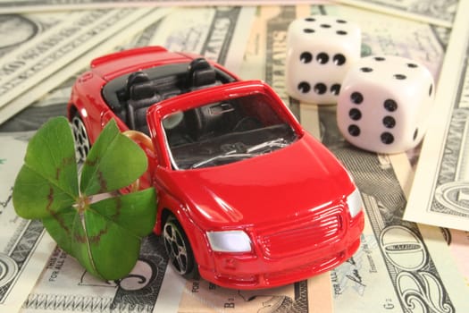 red car with lucky clover, dice and dollar notes