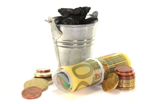 Bucket of coal and euro notes on a white background