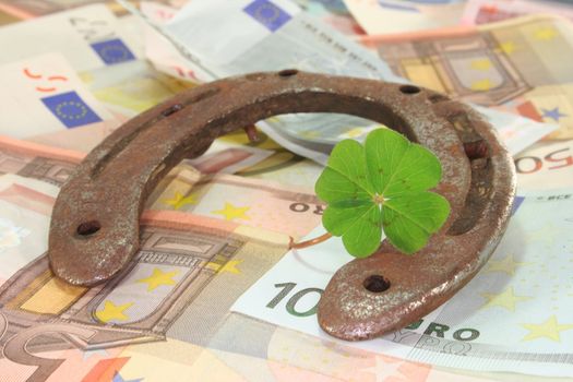 rusty horseshoe with clover and many euro notes