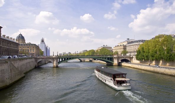 Passenger ship boat sails on the river Seine. View from the Quay. Urban scene. Paris