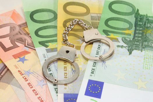 silver handcuffs on many large euro notes