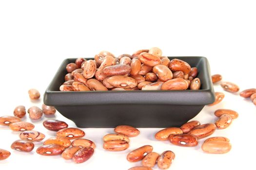 red mottled and dried pinto beans on white background