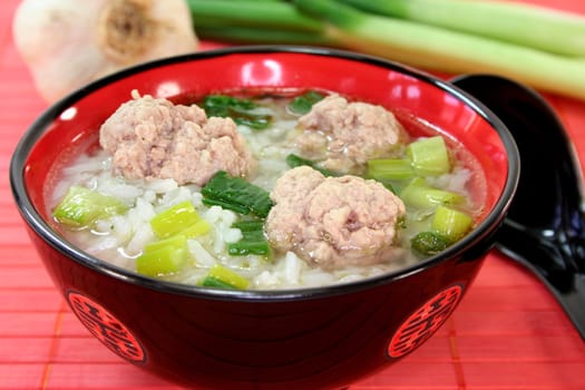 Thai rice soup with meat balls, jasmine rice and spring onions