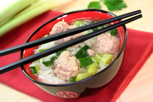 Thai rice soup with meat balls, jasmine rice and spring onions