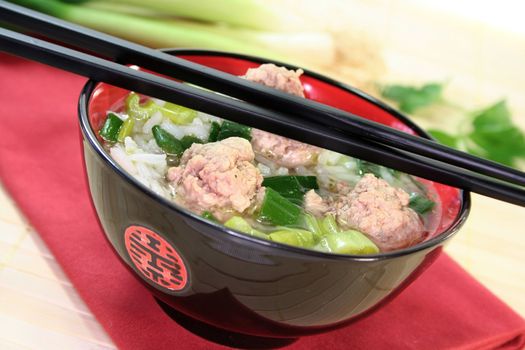 Thai rice soup with meat balls, jasmine rice and spring onions