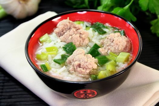 Thai rice soup with meat balls, jasmine rice and spring onions