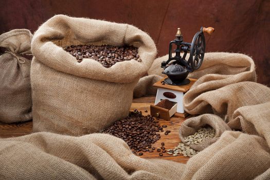 Studio photo of sack with scattered coffee and grinder