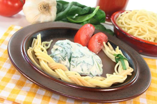 a pasta plait with spinach and cheese sauce with fresh ingredients
