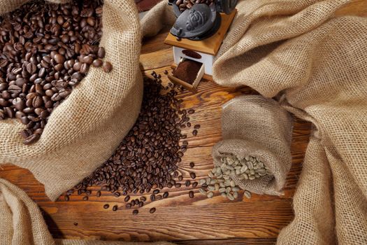 Studio photo of sack with scattered coffee and grinder