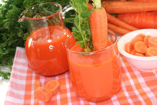 fresh carrot juice with a bunch of carrots and a carrot