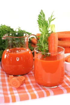 fresh carrot juice with a bunch of carrots and a carrot