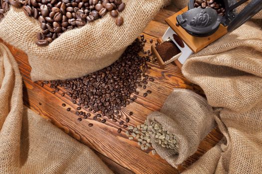 Studio photo of sack with scattered coffee and grinder