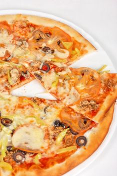 seafood pizza closeup with salmon, shrimps, tomato, pepper, olive and mozzarella cheese on a white background