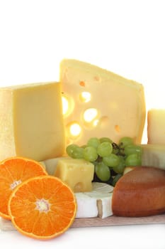 different varieties of cheese with fresh bright and dark grapes
