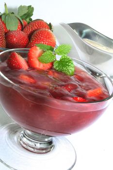 red fruit jelly with fresh strawberries and vanilla sauce
