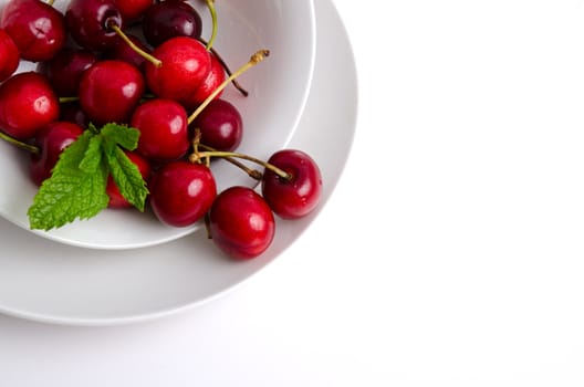 Red fresh cherries on plate background.