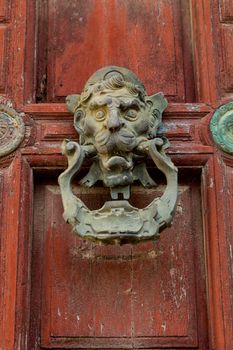 Detail of an ornate door knocker on the door of a building
