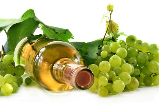 A bottle of white wine with grapes and leaves