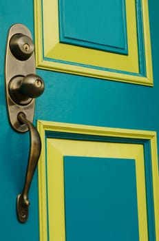 Turquoise colored door with metal doorknob and handle 
