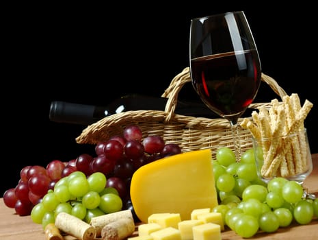 Red wine with grapes, cheese and sesame sticks for snack (Selective Focus, Focus on the wine glass)