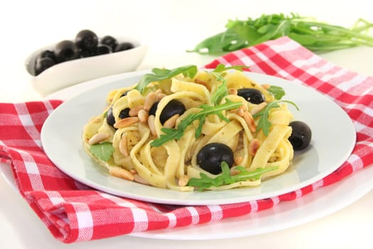 Pasta with pine nuts, pesto, olives and fresh rucola