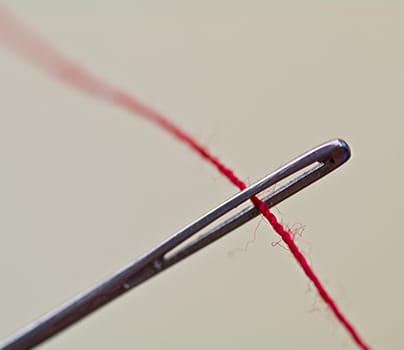 The eye of the needle with a red sewing cotton