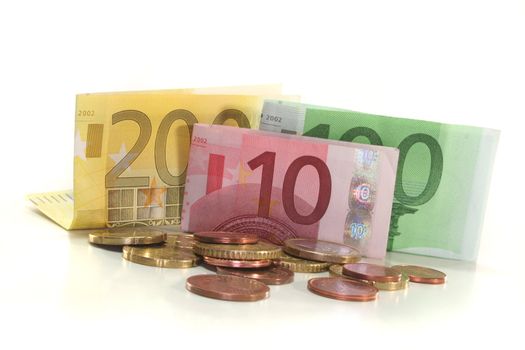 Euro banknotes and euro coins on a white background