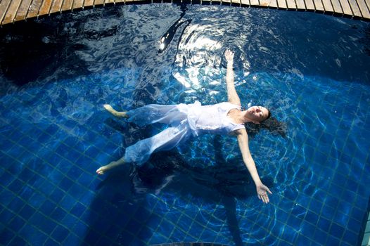 Woman relaxing in a paradise swimming pool in a resort in Porto Belo, Santa Catarina, Brazil