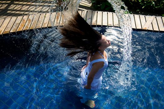 Woman relaxing in a paradise swimming pool in a resort in Porto Belo, Santa Catarina, Brazil