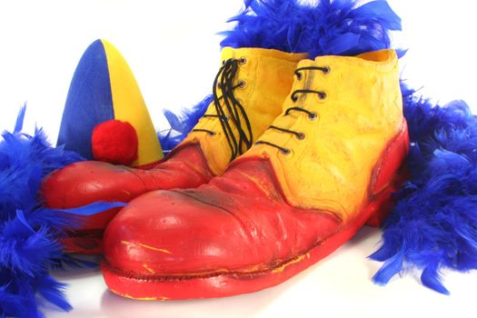 red and yellow clown shoes with blue feather boa and Harlequin hat