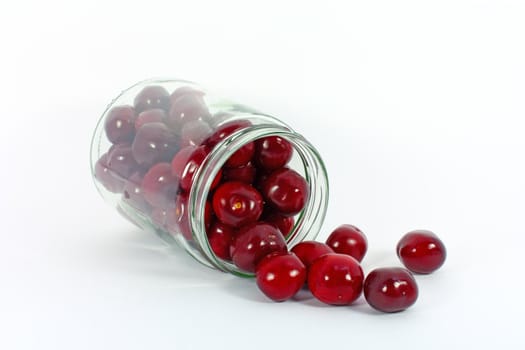 Sweet cherries in glass jar isolated on white