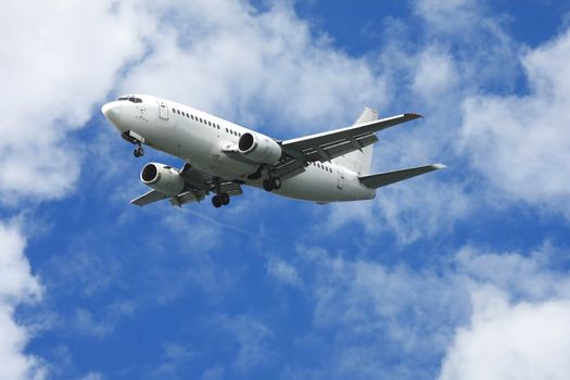 Jet aeroplane for passengers in a blue cloudy sky