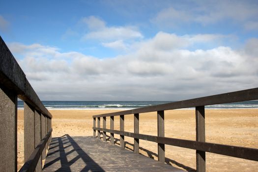 Wooden walkway leading to clean sea sand and beach