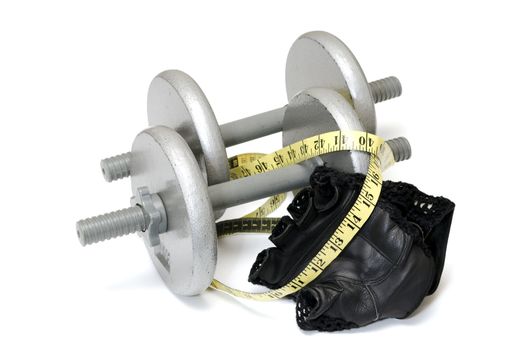 Two dumbbells, workout gloves, and measuring tape isolated on white background.