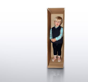 little boy is standing in the brown box alone