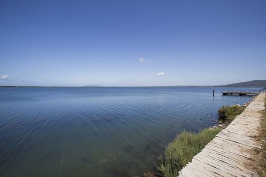 Over the dock, blue sky at the horizon, city of Orbetello in Tuscany.