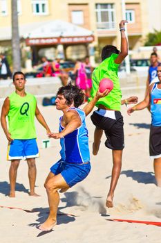 CADIZ, SPAIN - JULY 19: Unidentified players compete in a match between Zonabalonmano.com and BMPY Los Coñetas in the 19th league of beach handball of Cadiz on July 19, 2011 in Cadiz, Spain