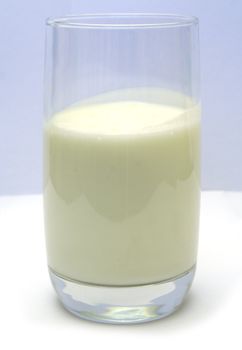 Glass filled with kefir on smooth white table