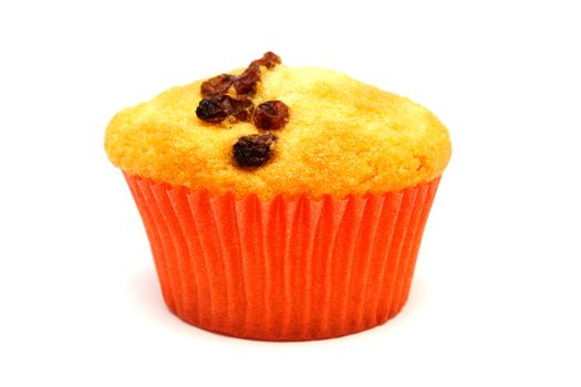 Zoomed tasty yellow muffin with many brown raisins